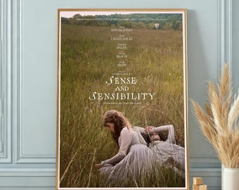 Puede incluir: Un póster de película enmarcado de Sense and Sensibility que muestra un campo de hierba alta con dos personas con ropa clara sentadas entre la vegetación. El texto incluye el título, los nombres del reparto y los créditos en blanco.