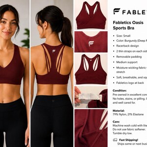 May include: A burgundy Fabletics Oasis sports bra featuring a V-neckline, a racerback design with two thin straps on each side, and a white logo on the back. The garment is made of 79% nylon and 21% elastane, offering medium support, moisture-wicking fabric, and removable padding.