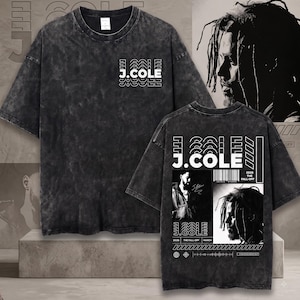 May include: A charcoal grey acid-wash t-shirt featuring a white J.COLE logo on the front chest. The back displays a large graphic with the J.COLE name, a barcode, the text 2026 THE FALL-OFF, and two black and white photographic portraits of a man.