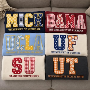 May include: Six folded sweatshirts featuring collegiate names and university titles. The designs include MICH for University of Michigan, BAMA for University of Alabama, UCLA, UF for University of Florida, SU for Stanford University, and UT for University of Texas at Austin, all with varied patterns like gingham, stripes, stars, and daisies.
