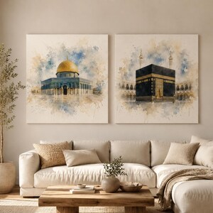 Könnte beinhalten: Zwei quadratische Wandkunstdrucke mit Aquarellillustrationen religiöser Wahrzeichen. Der linke Druck zeigt den Felsendom mit seiner goldenen Kuppel, während der rechte Druck die schwarze, würfelförmige Kaaba darstellt.