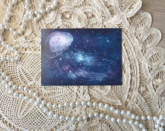 May include: A rectangular postcard featuring a digital illustration of a translucent jellyfish floating against a deep blue, starry night sky background with purple nebula clouds and glowing white stars throughout the composition.
