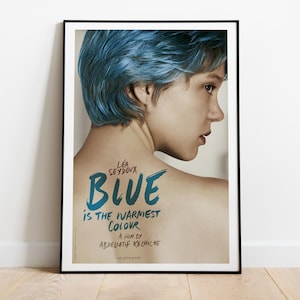 May include: A framed movie poster for Blue Is the Warmest Colour featuring a person with short blue hair seen from the back. The text reads Léa Seydoux, Blue Is the Warmest Colour, a film by Abdellatif Kechiche in a dark blue handwritten font.