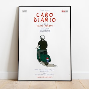 May include: A framed film poster for Caro Diario by Nanni Moretti. The white poster features a hand-drawn illustration of a person in a black shirt and grey trousers riding a green scooter. The text includes the title, director, and cast names.