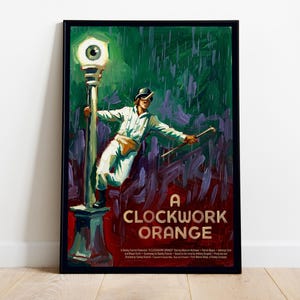 Pode incluir: Um cartaz de filme emoldurado de A Clockwork Orange apresentando uma figura em roupas brancas segurando uma bengala enquanto se apoia em um poste de luz com um olho na luz. O fundo é uma lavagem abstrata verde escura e roxa com texto vermelho.
