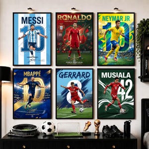 May include: Six framed posters featuring soccer players Messi, Ronaldo, Neymar Jr, Mbappe, Gerrard, and Musiala in action. Each print displays the player's name, jersey number, and team colors, arranged in two rows on a wall above a black cabinet.