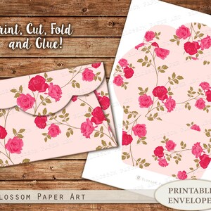 K&ouml;nnte beinhalten: Druckbare Briefumschlagvorlage mit einem rosafarbenen Blumenmuster mit rosa Rosen und goldenen Bl&auml;ttern. Der Text "Drucken, Ausschneiden, Falten und Kleben!" befindet sich oben im Bild. Der Text "Druckbare Umschl&auml;ge" befindet sich unten im Bild.