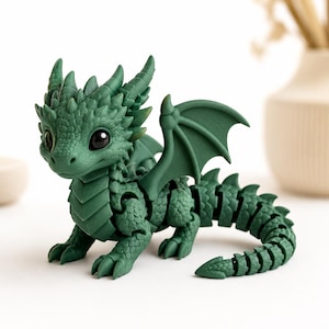 May include: A small, articulated green dragon figurine with large black eyes, textured scales, and wings. The creature features a segmented, flexible tail and body design, with multiple spikes along its back and head, standing in a quadrupedal pose.