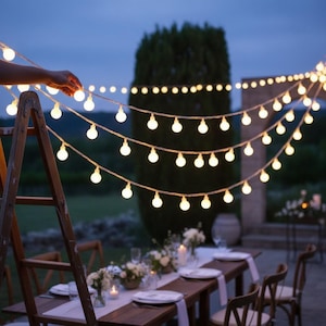 May include: A string of round, warm white LED globe lights draped across an outdoor setting. The lights are suspended in multiple horizontal rows, creating a festive illumination. A wooden ladder stands to the side, supporting the light strand.