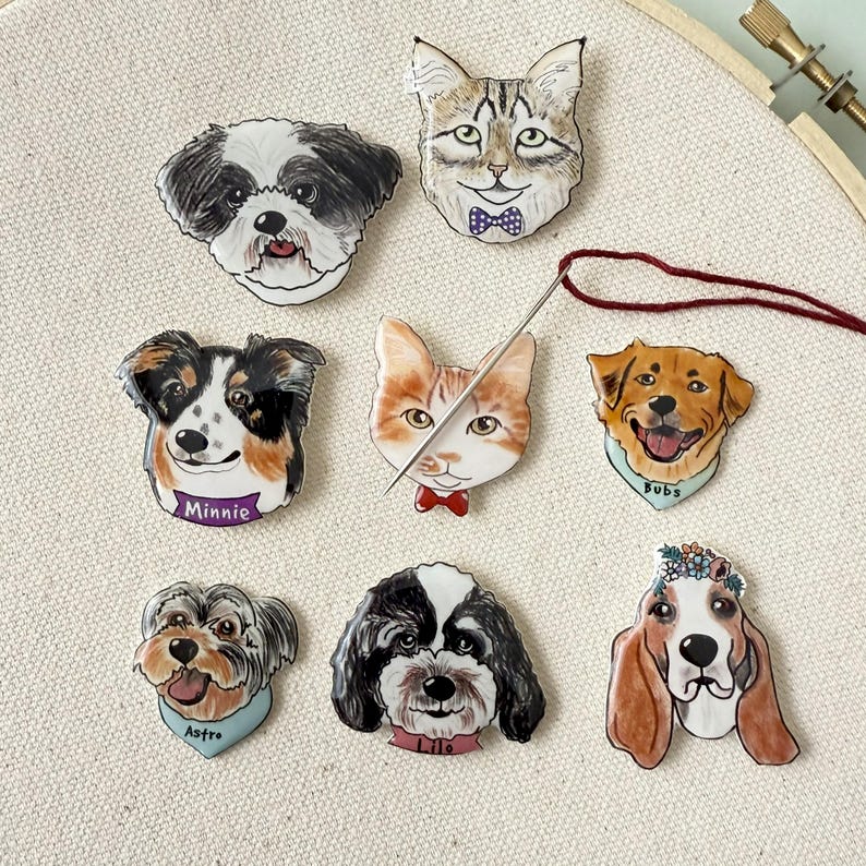 May include: A collection of pet-themed pins featuring dogs and cats. Each pin is a detailed illustration of a pet's face, with some wearing bow ties or bandanas. The pins are in various colors and styles, perfect for pet lovers.