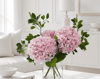Roze zijden hortensia kunstbloemstuk in een transparante glazen cilindervaas.