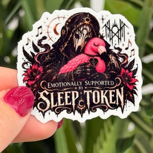 May include: A die-cut sticker featuring a dark, hooded figure with a white mask holding a bright pink flamingo. The design includes red flowers, musical notes, and the text "EMOTIONALLY SUPPORTED BY SLEEP TOKEN" in a stylized, gothic-inspired font.