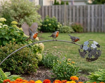 May include: A garden ornament featuring three realistic robin figurines perched on a curved metal rod. One robin has its wings spread wide, while the others stand still. At the end of the rod is a spherical metal sculpture made of flower shapes.