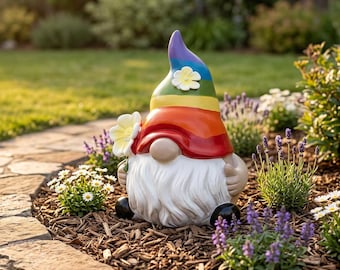 May include: A garden gnome figurine featuring a tall, pointed hat with horizontal stripes in rainbow colors, topped with a small white flower. The gnome has a long white beard, a tan nose, and holds a white flower in its hand.