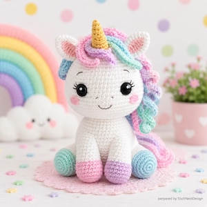 May include: A white crocheted unicorn plush toy with a gold horn, pastel pink, blue, and purple mane and tail, and black safety eyes. The unicorn has pink blush on its cheeks and sits on a pink crocheted doily. Text reads: prepared by StichNestDesign.