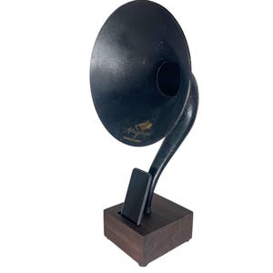 May include: A black vintage-style gramophone with a large horn and a wooden base. The horn is curved and has a circular opening. The base is a dark brown square. The gramophone has a classic, antique aesthetic.