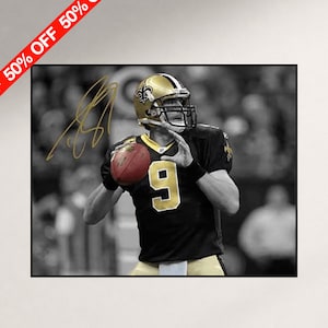 May include: A black and white photograph of a football player wearing a black jersey with the number 9 in gold and a gold helmet with a fleur-de-lis logo. The player is holding a brown football, and a gold signature is visible on the image.