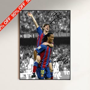 Puede incluir: Un póster rectangular vertical que muestra un fondo de estadio en blanco y negro con dos jugadores de fútbol con camisetas azules y rojas. Un jugador lleva al otro a cuestas. La imagen incluye dos firmas distintas en tinta negra.