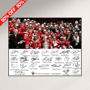 Op de afbeelding: Een herdenkingsfoto van het 2015 Stanley Cup kampioensteam Chicago Blackhawks in rood-zwarte tenues, met de Stanley Cup in het midden en een verzameling gedrukte handtekeningen van spelers onderaan de afbeelding.