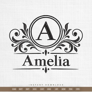 Könnte beinhalten: Ein schwarzes Maschinenstickmuster mit dem Buchstaben A in einem kreisförmigen Rahmen, flankiert von symmetrischen Schnörkeln und floralen Verzierungen. Der Name Amelia ist darunter in einer Serifenschrift gestickt.