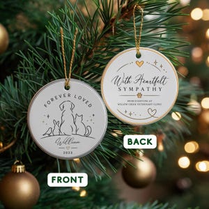 Può includere: Due ornamenti rotondi in ceramica bianca con bordo dorato e cordini dorati. Il fronte presenta il testo FOREVER LOVED, un disegno al tratto di un uccello, coniglio, cane e gatto, il nome William e 2023. Il retro riporta With Heartfelt SYMPATHY.