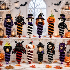 May include: A collection of twelve crocheted Halloween ornaments featuring various characters including a witch, a skeleton, a pumpkin, a plague doctor, a clown, and a grim reaper, each attached to a spiral base with a small bell at the bottom.