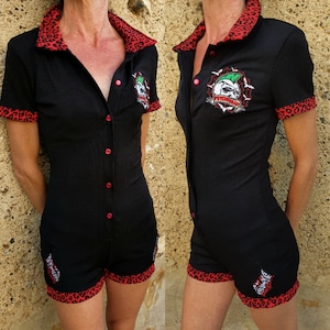 May include: Black short-sleeved jumpsuit with a red leopard print trim. The jumpsuit has a button-up front and features an embroidered skull graphic on the chest. The text "Psycho Killer" is embroidered below the skull.