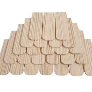 May include: A collection of light-coloured wooden shingles arranged in a layered, overlapping pattern. Each individual shingle features a rectangular shape with a rounded bottom edge and visible natural wood grain patterns running vertically.
