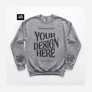 May include: A heather grey crewneck sweatshirt featuring the black text "TRUE FORM MOCKUPS" and "YOUR DESIGN HERE" printed on the centre chest and on both sleeves. The garment has long sleeves, a ribbed collar, and ribbed cuffs and hem.