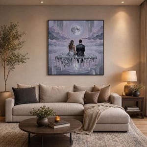 A large, framed oil painting of a couple on a dripping silver platform under a full moon hangs above a sectional sofa with pillows, a coffee table, and a lamp.