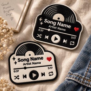 Könnte beinhalten: Zwei bestickte Aufnäher in Form von Musik-Player-Oberflächen. Ein Aufnäher ist schwarz mit weißem Text und Details, der andere ist weiß mit schwarzem Text und Details. Beide zeigen eine Schallplattengrafik, Platzhalter für Song- und Künstlernamen, eine Fortschrittsleiste, Wiedergabesteuerungen und ein kleines rotes Herzsymbol.