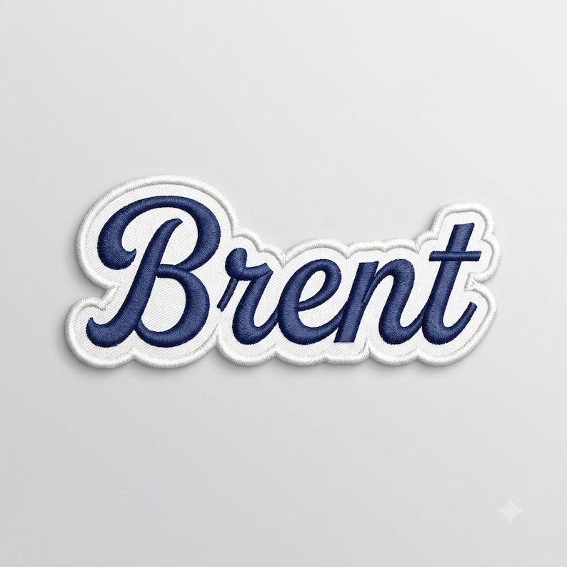 以下が含まれることがあります： 濃いネイビーブルーの筆記体フォントで「Brent」という名前が刺繍されたワッペン。文字はテキストの形状に沿った太い白い縁取りで囲まれており、布製アップリケとしてすっきりと明確な輪郭を作り出しています。