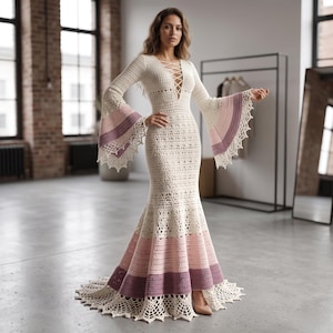 May include: A floor-length crochet dress in cream, featuring a deep V-neckline with lace-up detailing, long flared bell sleeves, and a fitted bodice that transitions into a wide, multi-colored skirt with horizontal bands of pink and purple.