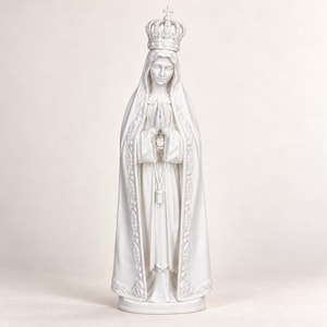 Könnte beinhalten: Eine weiße Statue einer Figur in einem langen, fließenden Gewand und einem Schleier, mit gefalteten Händen in Gebetshaltung. Die Figur trägt eine verzierte Krone auf dem Kopf und das Gewand zeigt detaillierte florale Stickereien.