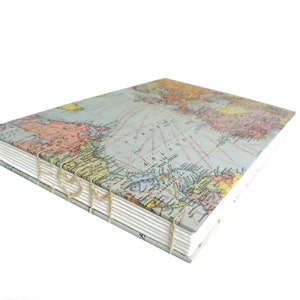 May include: A square book with a vintage map print cover featuring the North Atlantic Ocean. The book has exposed coptic stitching along the spine, utilizing thick, light-colored thread to bind the white paper pages together in a visible pattern.