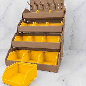 Pode incluir: Um organizador de armazenamento em camadas com uma estrutura castanha e quatro níveis de recipientes amarelos. A unidade inclui um painel superior com seis ganchos para pendurar itens. Um recipiente amarelo está separado à frente.