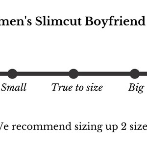Puede incluir: Gr&aacute;fico que ilustra la gu&iacute;a de tallas para una camiseta Slimcut Boyfriend para mujer. La escala va de "Peque&ntilde;o (talla m&aacute;s grande)" a "Grande (talla m&aacute;s peque&ntilde;a)". El texto recomienda subir dos tallas.