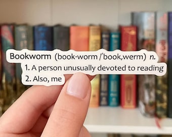 May include: A white die-cut sticker featuring black text that reads: Bookworm (book·worm /ˈbook,werm) n. 1. A person unusually devoted to reading 2. Also, me. The sticker has a matte finish and is shaped to follow the contour of the printed dictionary definition.