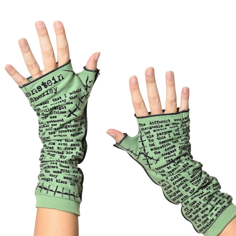 Puede incluir: Guantes sin dedos verde claro con costuras negras y texto de Frankenstein de Shelley. Los guantes est&aacute;n hechos de un material suave y cubren la mano y la mu&ntilde;eca.