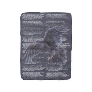 May include: A dark grey throw blanket with a large raven illustration and text from a poem. The raven has outstretched wings. The text is in a dark font and covers the background.