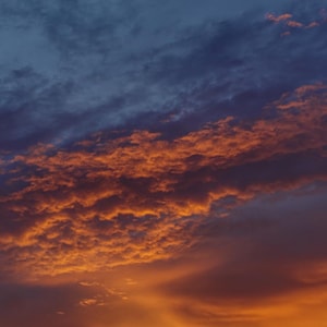 Pôr do sol vibrante e luminoso com nuvens douradas alaranjadas, fotografia digital para impressão.
