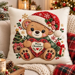 May include: A square off-white throw pillow featuring an embroidered brown teddy bear wearing a red Santa hat and a green scarf. The bear holds a red heart with the text Merry Christmas. The design includes a small Christmas tree and gifts.