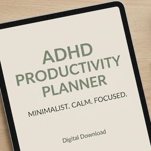 Peut inclure: Une tablette numérique affichant le texte ADHD PRODUCTIVITY PLANNER, MINIMALIST. CALM. FOCUSED. et Digital Download en police vert foncé sur un fond crème clair. La tablette est posée sur une surface en bois clair à côté d'un stylo.