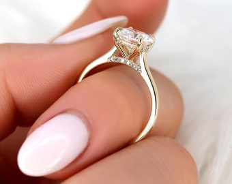 May include: A gold engagement ring featuring a large oval-shaped centre stone with smaller stones set in a pave setting around the centre stone.
