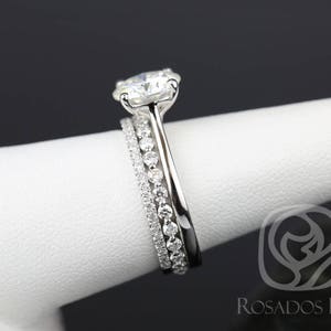 May include: A three-piece diamond engagement ring set with a large center stone and two smaller bands.