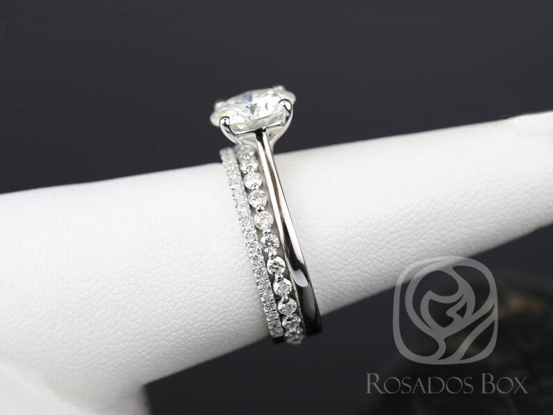 May include: A three-piece diamond engagement ring set with a large center stone and two smaller bands.