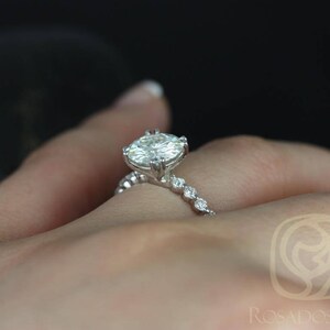 May include: A silver engagement ring with a large oval-shaped diamond and a band of smaller diamonds.