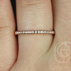 Peut inclure: Une délicate bague en or rose perlée sur un doigt.