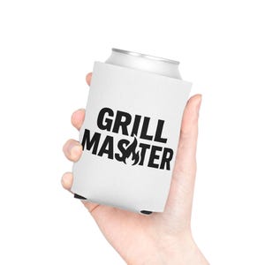 A hand holding a white can with the text "GRILL MASTER" printed on it.