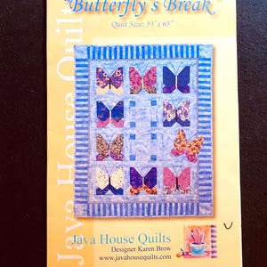 May include: A quilt pattern titled Butterfly's Break by Java House Quilts, featuring a 134.6 cm x 165.1 cm quilt design with multiple colourful butterfly blocks arranged in a grid, surrounded by a blue and white striped border on a yellow background.